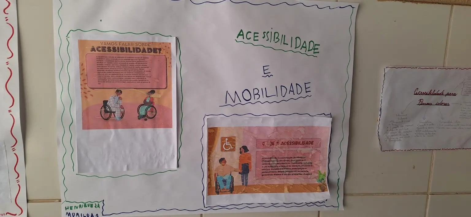 Cartaz branco com moldura verde e o título Acessibilidade e mobilidade. Duas folhas impressas em tons alaranjados explicam acessibilidade e apresentam ilustrações de pessoas, incluindo uma pessoa em cadeira de rodas.